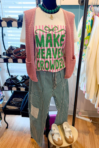 Mannequin wearing a pink cardigan, striped pants, and a graphic t-shirt in a store setting.